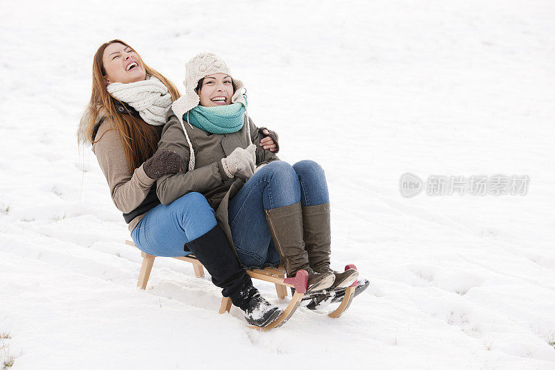 两个朋友坐在雪橇上