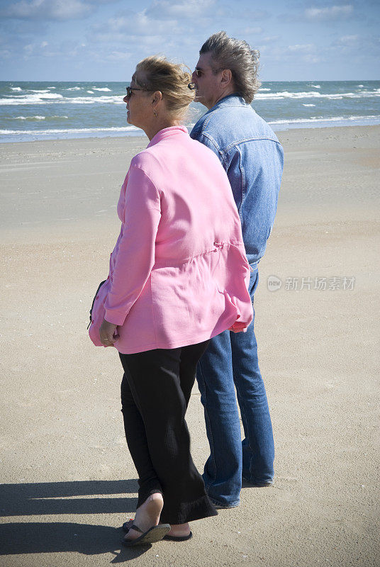 沙滩上的一对白人情侣，50年了，手牵着手
