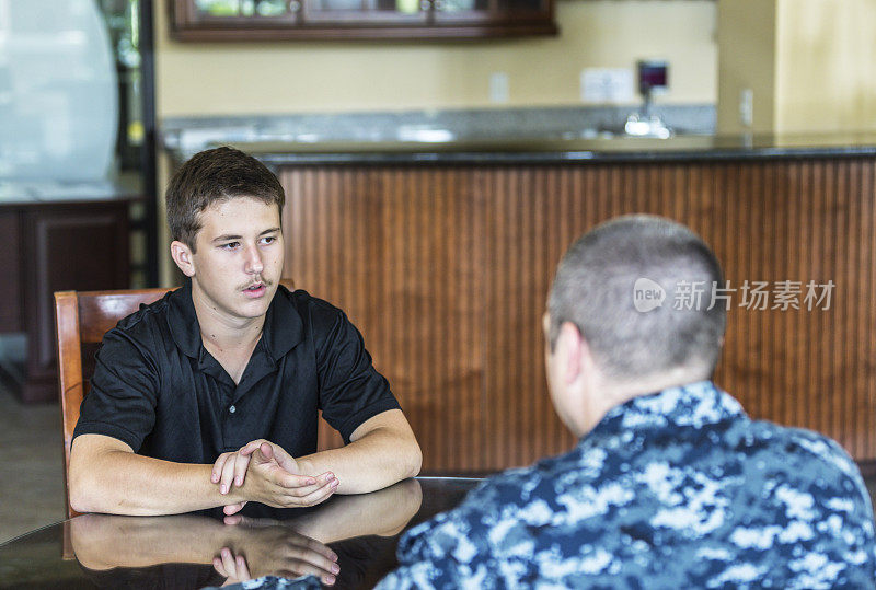 青少年与美国海军征兵人员交谈