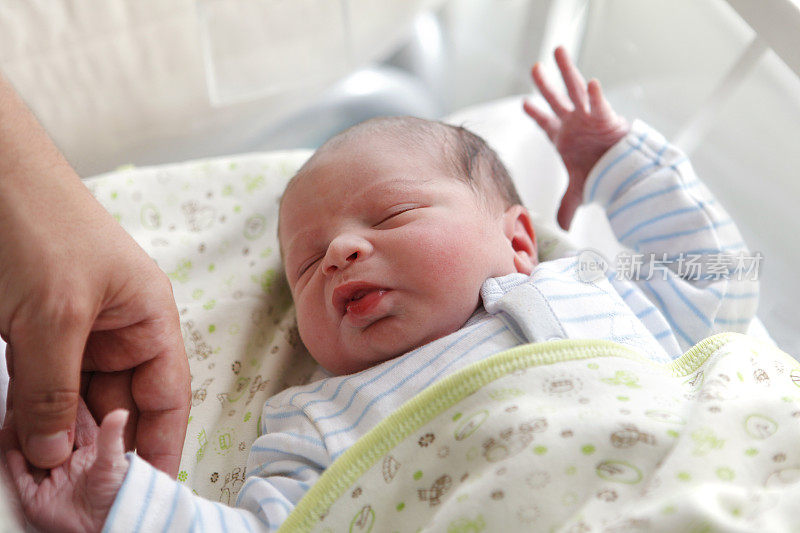 新生婴儿握着父亲的手指