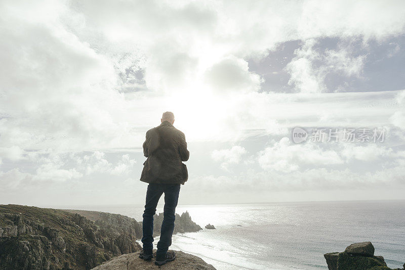 一名男子站在悬崖上欣赏着南康沃尔的景色。