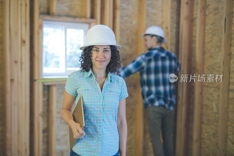 一名女性房主正在建筑项目中手持数码平板电脑