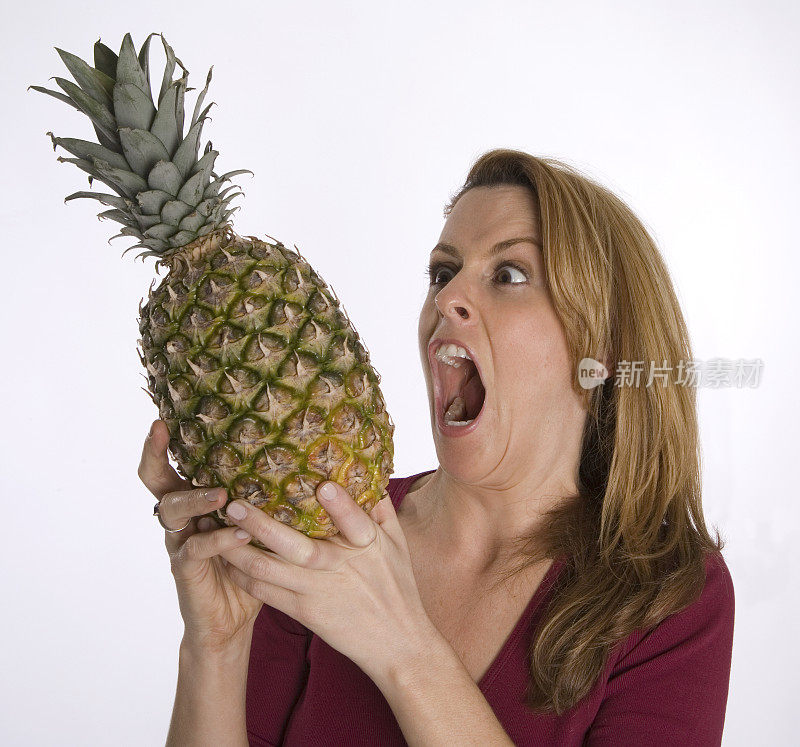 一个女人准备咬菠萝