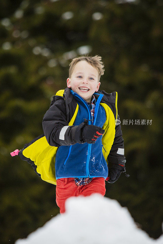 小男孩在外面玩雪。