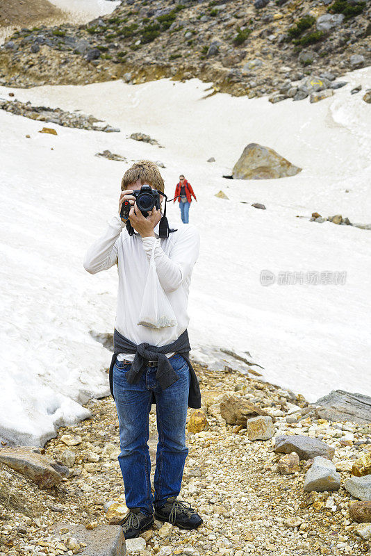 一名男子在通往Tokachidake活火山的道路上拍照