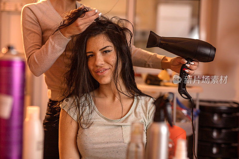 一名年轻女子正在美发店做头发。