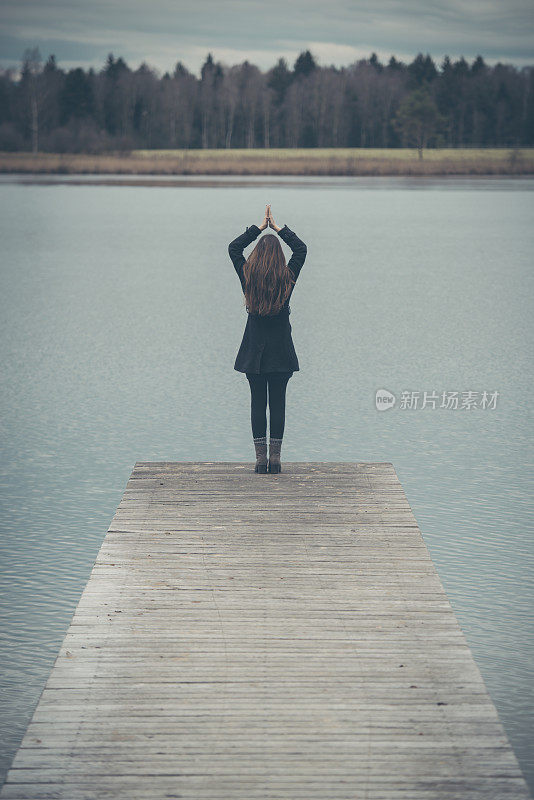 一个年轻女子在奥地利湖边的码头上