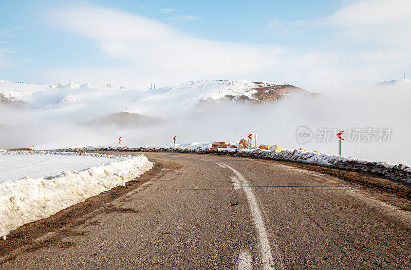 道路穿过雪山向下延伸