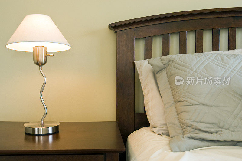 现代卧室套间中的床、边桌和台灯