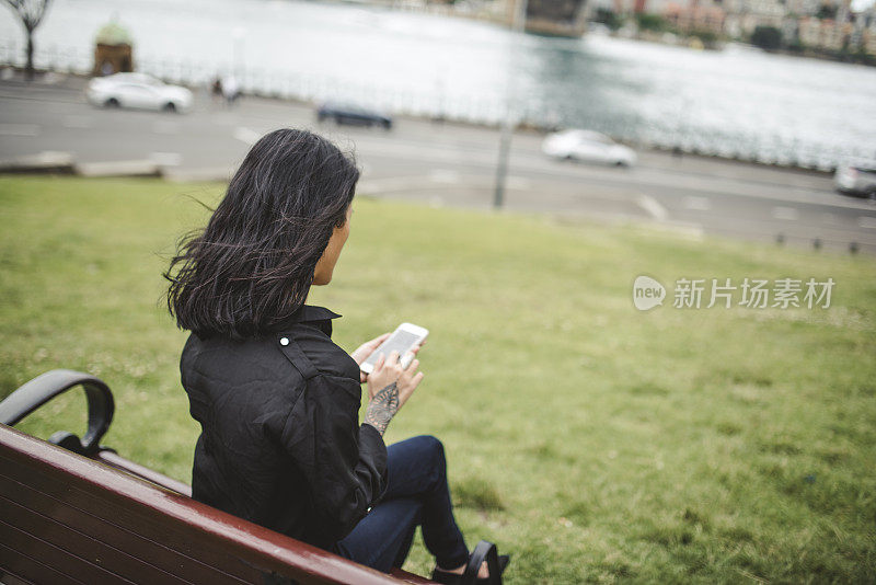 在公园里用智能手机的亚洲女人