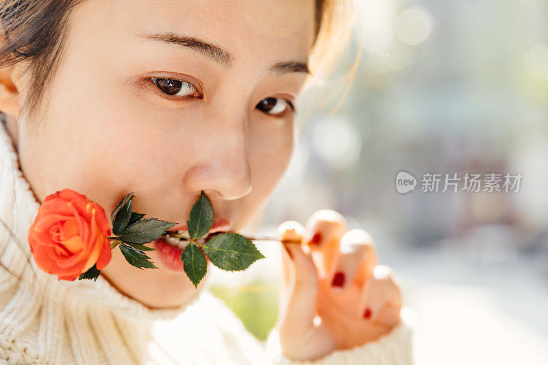 亚洲女孩在太阳耀斑下的红花，上海，中国