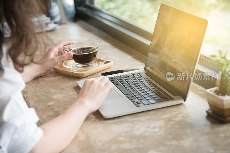 在家庭办公室工作的女人把手放在键盘上。咖啡休息后在家办公，在电脑上工作