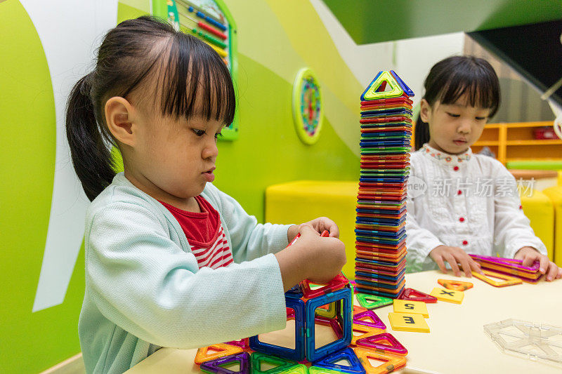 亚洲华人小女孩玩彩色磁铁塑料积木套件