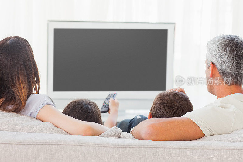 一家人坐在沙发上一起看电视
