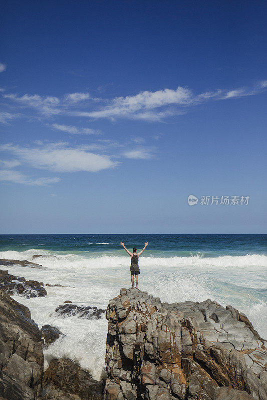 年轻人站在努萨岬的岩石边缘
