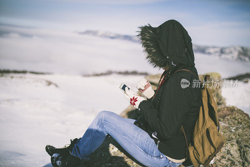 女孩在户外的山峰上发短信。