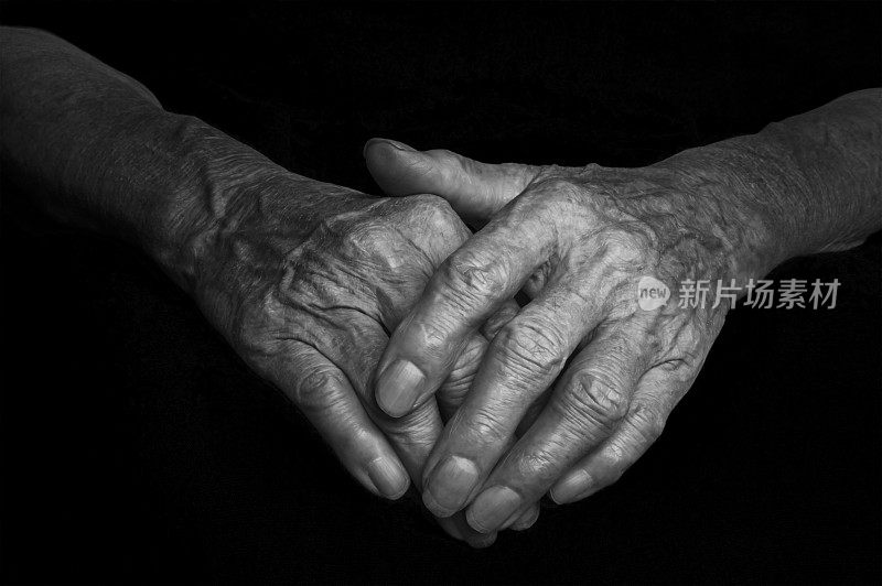 一个满脸皱纹的老妇人的手。