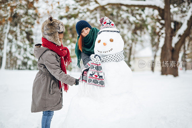 妈妈和女儿在堆雪人