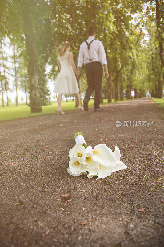 婚礼花束躺在地上，新婚夫妇离开