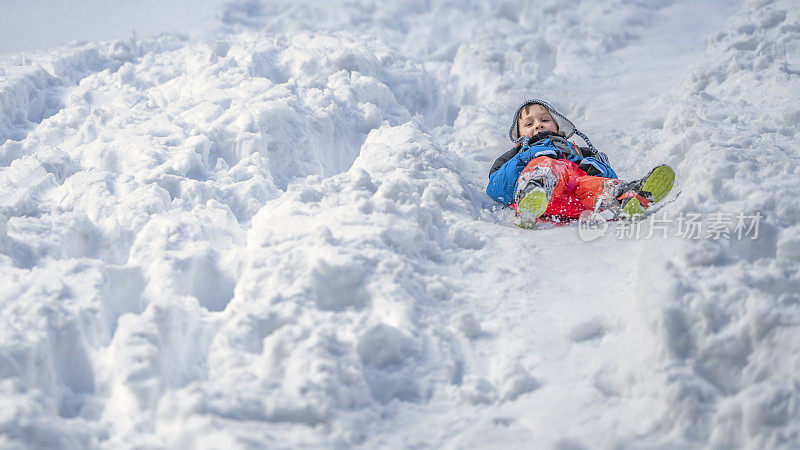 男孩在雪地上滑行