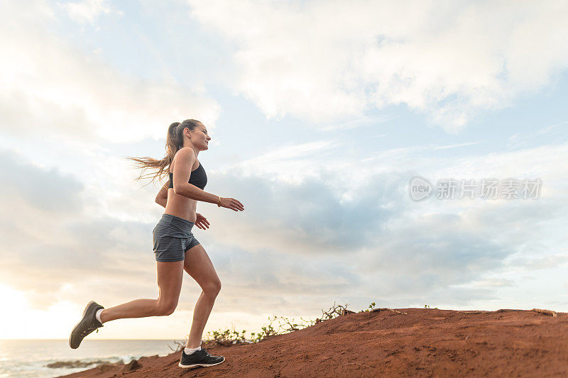 在夏威夷海岸线上独自跑步的女性