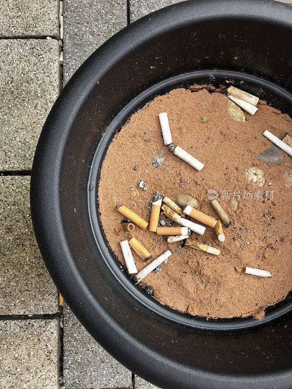 烟头和烟灰缸上的烟头的图片。烟头和烟灰缸上的烟头使用建筑工地的沙子来防止吸烟引起的火灾