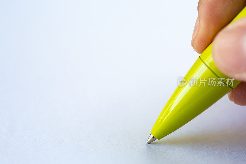 女人的右手拿着一支绿色的笔，在白纸背景上写信，笔记本，特写和微距拍摄，选择性聚焦，沟通，文具概念