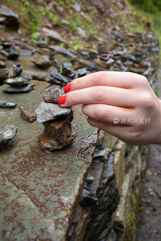 一个女孩的手堆起小石头的特写。