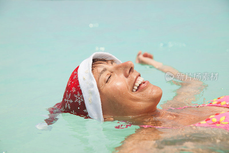 快乐的成年女人在海里享受圣诞节