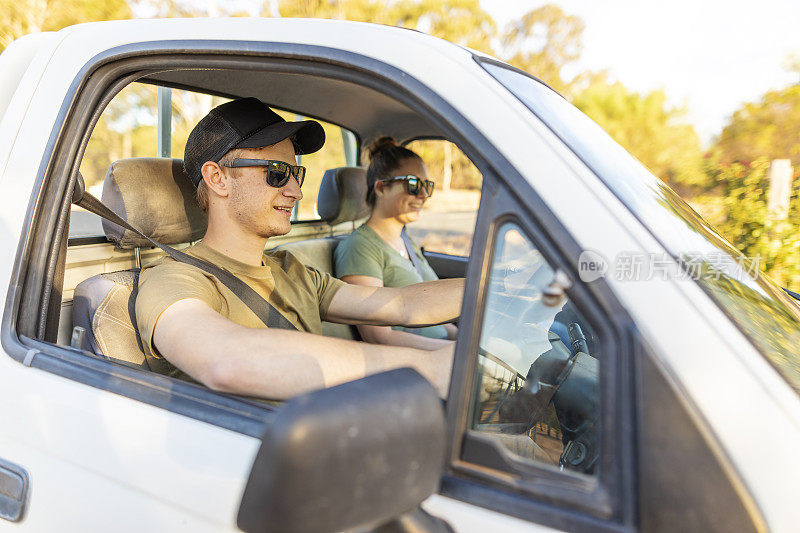 一对年轻夫妇在农场的土路上开车