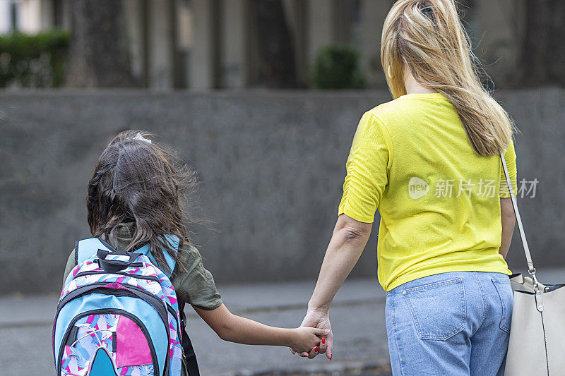 妈妈正带着他的小女儿去学校