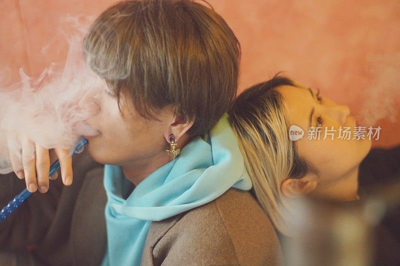 两个年轻的男男女女在抽水烟