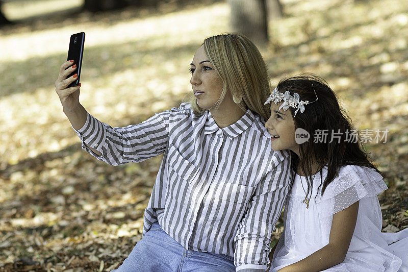 一位女士正在秋季公园和她的女儿自拍