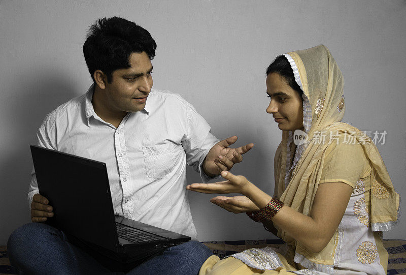印度夫妇在家里用笔记本电脑