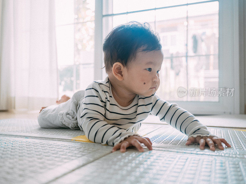 小男孩在垫子上笑着。