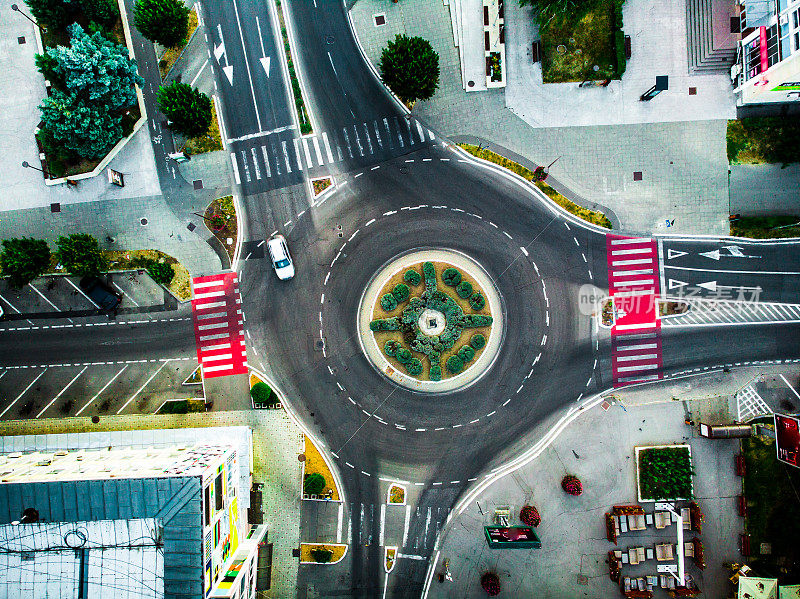 空中俯瞰汽车在城市的环岛上行驶