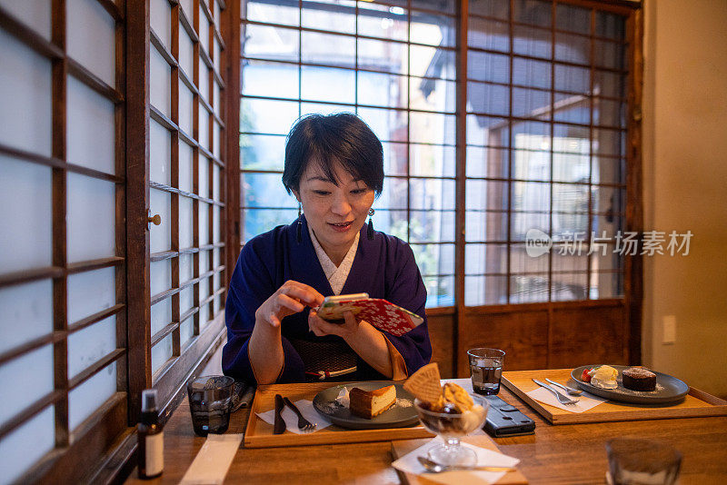 穿着和服的日本女人在日本餐厅使用智能手机