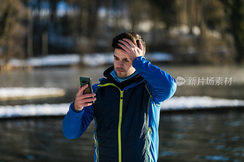 男人站在湖边发短信时很生气。