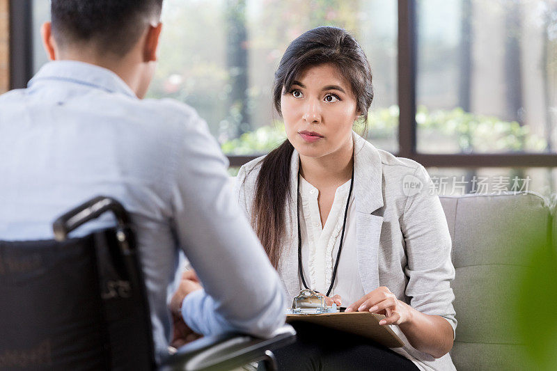 细心的女医生与轮椅上的男子谈话