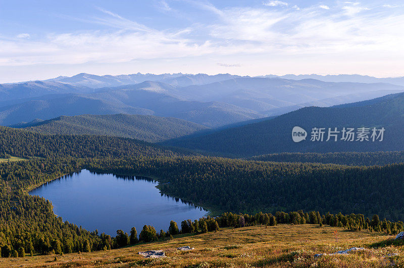 针叶林。西伯利亚。湖泊和山脉在黎明与美丽的云彩