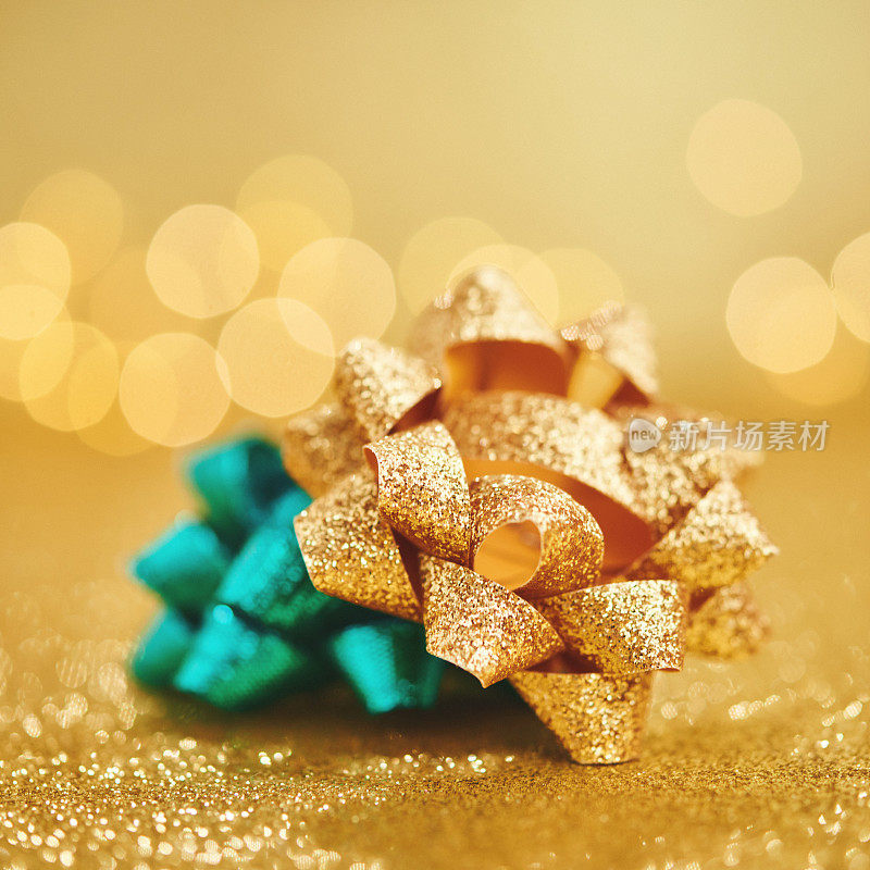 圣诞礼物蝴蝶结在闪闪发光的黄金背景