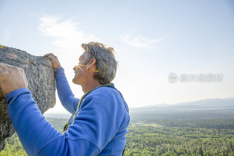 男登山运动员登上山顶的最后一步