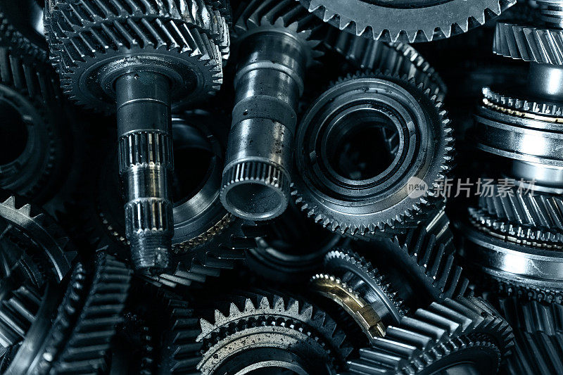特写汽车自动变速器齿轮部分拆装在工作台上，在车库或修理厂站进行修理服务或维护。车辆的部分细节。复杂的产业机制背景