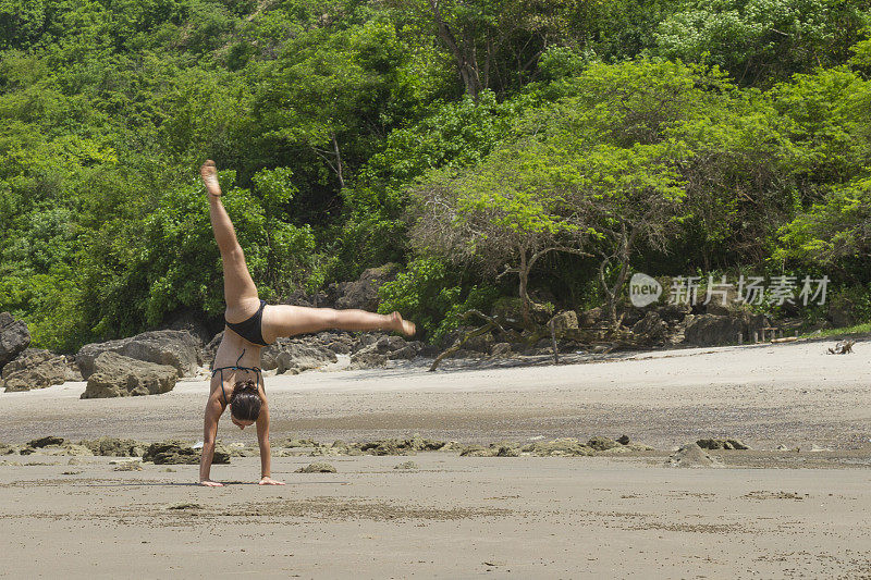 在海滩上做瑜伽和杂技体操的女体操运动员