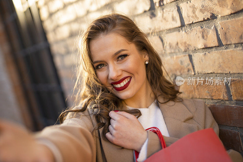 快乐女人挎着红色购物袋的自画像