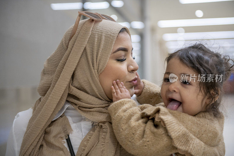 穆斯林母亲亲吻她年幼的女儿