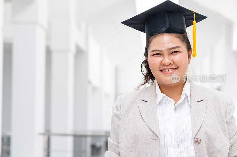戴着黄流苏黑毕业帽的女博士毕业生们在大学里。