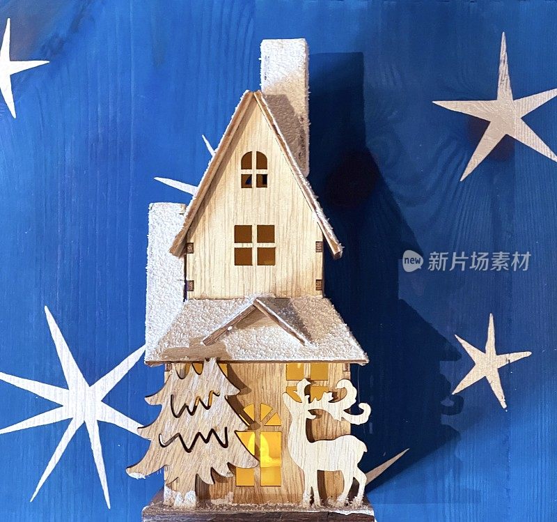 木制玩具屋，照明，在圣诞星星的背景