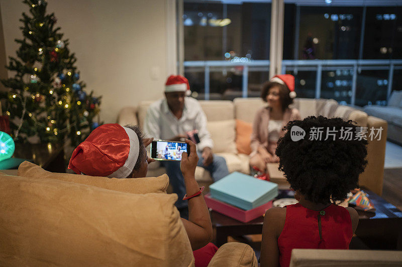视频通话期间，一家人在沙发上打开圣诞礼物