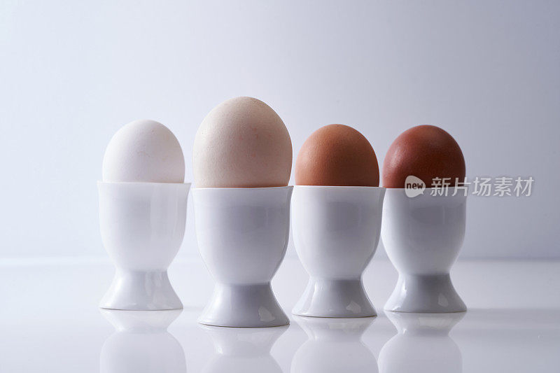 鸡蛋杯里放着不同颜色的鸡蛋